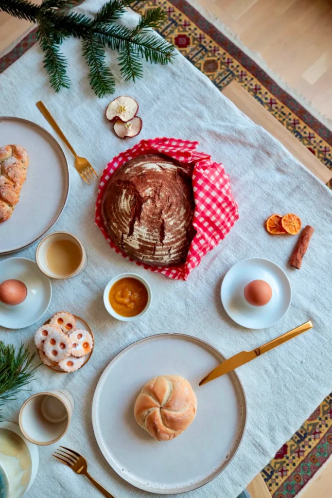 Brotlaib im rotkarierten Bienenwachstuch auf weihnachtlichem Frühstückstisch