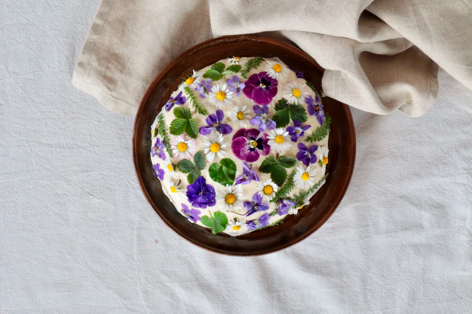 Mit Blüten und Kräutern belegter Brotlaib