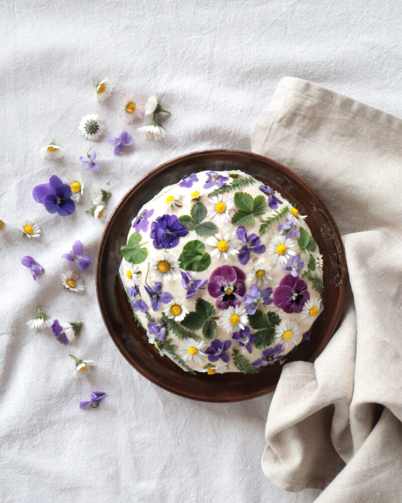 Mit Blüten und Kräutern belegter Brotlaib
