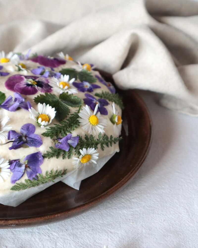 Mit Blüten und Kräutern belegter Brotlaib