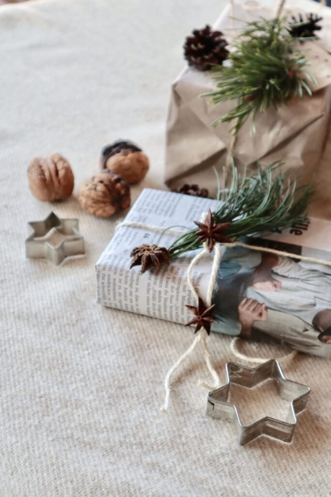 In Zeitungspapier und Tücher verpackte Geschenke mit Naturdeko