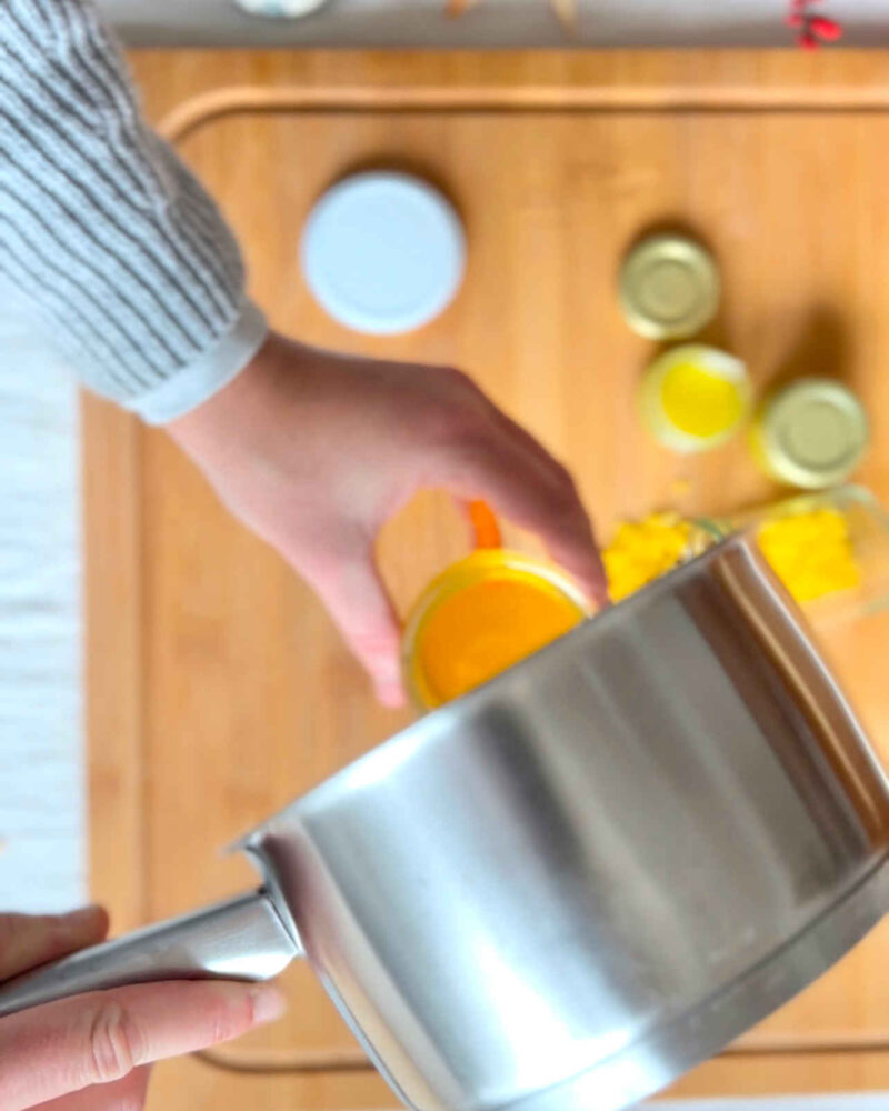 Ringelblumenöl wird aus dem Topf in ein Glas geleert