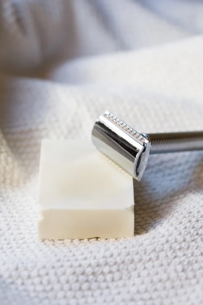 Olivenölseife auf Handtuch mit Rasierhobel