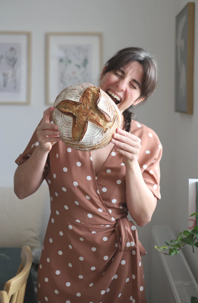 Frau beißt in einen Laib Brot