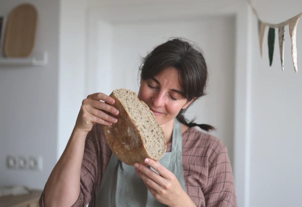 Frau riecht an angeschnittenem Sauerteigbrot